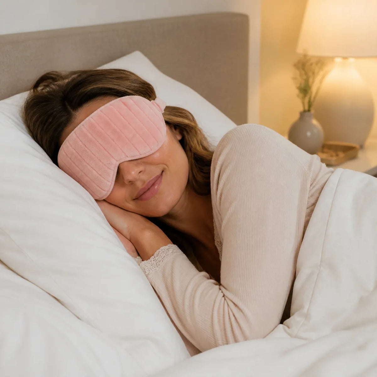 Frau trägt die hellrosa verstellbare MUMUSO Schlafmaske im Bett