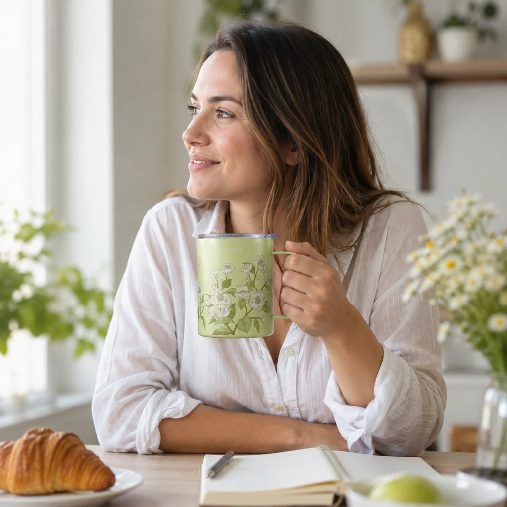Grüner floraler Isolierbecher in einer Frühstücksszene