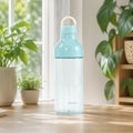 Blaue Macaron Kunststoff Trinkflasche 600 ml auf einem sonnigen Tisch