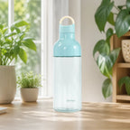 Blaue Macaron Kunststoff Trinkflasche 600 ml auf einem sonnigen Tisch